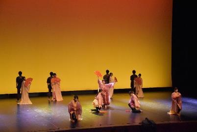 舞台上で劇を披露している高校生たちの様子の写真