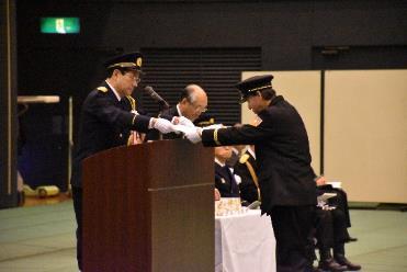 功績あった消防隊員が代表者から表彰されている処の写真