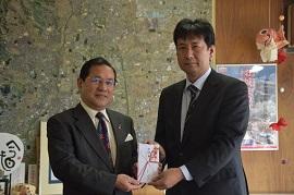 奈良日化サービス株式会社の会長が、市へ寄附を手渡した時の写真