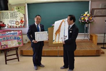 感謝状を持つ大阪ガス株式会社速水氏と大型絵本を持つ市長の写真