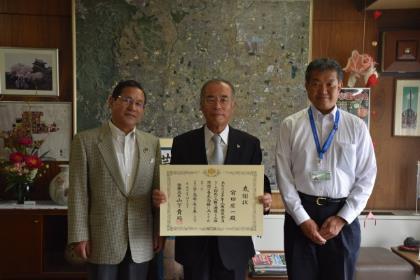 法務大臣から贈られた感謝状を手にして宮田氏、市長、人権擁護課課長が3人並んで記念撮影をしている様子