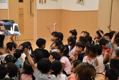 園児たちが元気よく手をあげて質問をしようとしている写真
