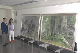 大きなキャンパスに描かれた2枚の大樹の絵を鑑賞している市長の様子の写真