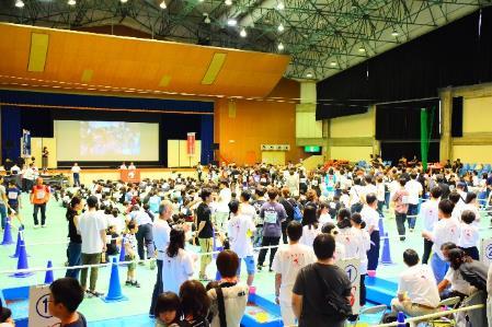 金魚すくい大会の参加者たちが三の丸会館の構内で集まっている様子の全体写真