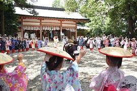 賣太神社で輪になって阿礼さま音頭にあわせた踊りを披露している笠を頭にかぶった浴衣姿の女性たちの様子の写真