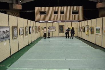 体育館に設置されたパネルに絵が並んで展示されている様子の写真