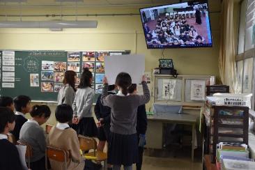 テレビに向かい紙を掲げシンガポールの生徒達と交流している写真