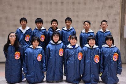青い防寒ジャンパーを着た小学生12人の駅伝代表選手の写真