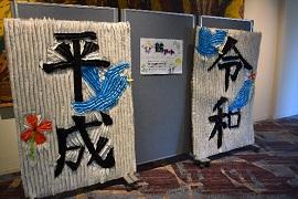 千羽鶴で平成と令和と描かれた作品が壁へと展示されている写真