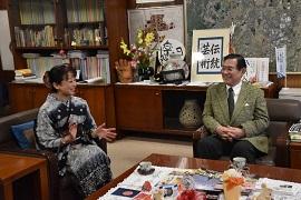 木目の市長室にて着物姿の南かおりさんと共にソファに座り談笑する市長の写真