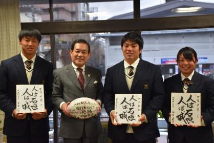 サインを持つ高校生三人とラグビーボールを持つ市長が並んで撮影された写真