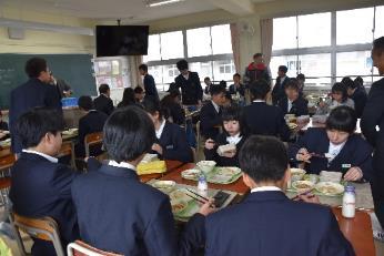 制服姿で給食を食べる中学生徒達の写真