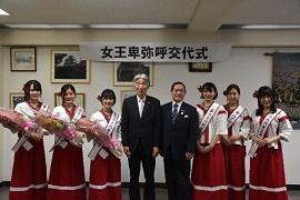 花束を持った紅白衣装の女性達が市長等二人を中心に並び撮影された写真