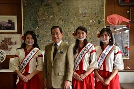 白と赤の衣装にたすきをした3人の女性と市長の記念写真