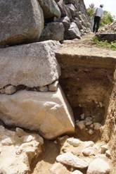 発掘された天守台の石垣が土に埋もれている写真