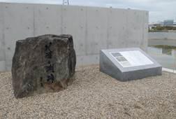 砂地に設置された岩に直接文を掘った「八条ヶ渕跡」石碑と、近代的な「洞渕と八条ヶ渕」碑文の写真