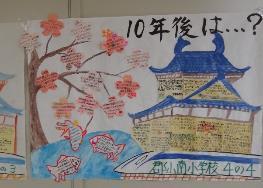 白い壁に貼られた「10年後は…？」の文字と城と文字が花びらに書かれている桜の木が描かれたイラストの写真