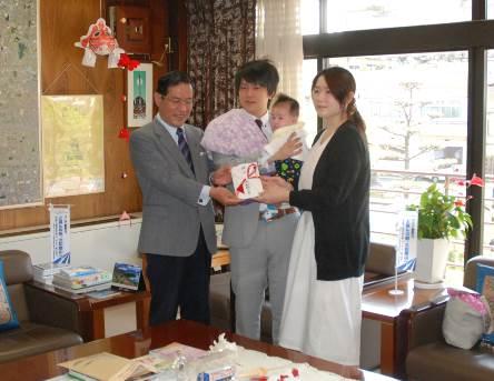 市長から記念品・助成金を受けとる夫婦と赤ちゃんの写真