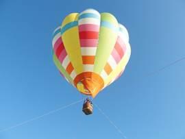 青空に浮かぶカラフルな色をした気球の写真