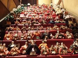 階段に赤い布を敷き、沢山のひな人形が隙間なく飾られた階段雛の写真
