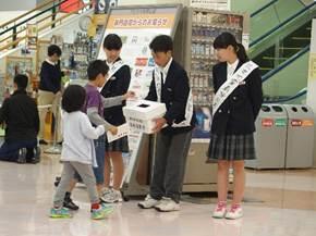 商業施設で募金を募る中学生の前に、募金に来た2人の子供の写真