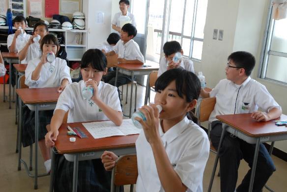 教室でペットボトルに入った地下水を飲む中学生たちの写真