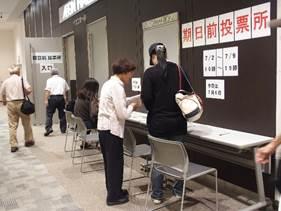 期日前投票に来場する有権者が職員に手順を教わっている処の写真