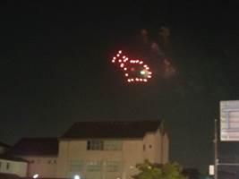 夜空を赤い金魚の形をした花火が打ち上げられた時の写真