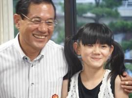 民謡民舞少年少女全国大会で優勝した小学4年生の佐野就美(つぐみ)さんと市長のツーショットの写真