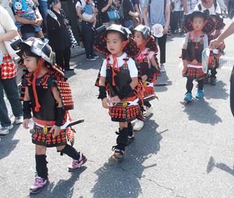 武者行列で筒井幼稚園の児童が甲冑を来て行列ができている写真
