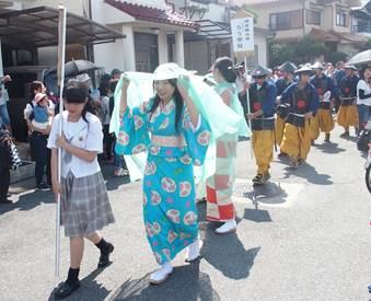 艶やかな侍女の衣装をきた女子高生とその後ろに並ぶ甲冑姿の男子高校生たちの写真