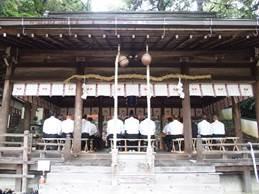 矢田坐久志玉比古神社の木製の寺の中で白シャツの人たちが並んでいる写真