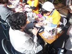 模擬店で参加者の女性に福祉ネイルを実施している土橋さんの写真