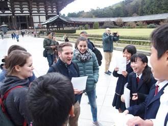 奈良公園に観光に来ている外国人に英語で話しかける校外学習を行っている写真