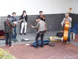 やまと郡山城ホールの外で演奏の練習をしているバンドメンバーの写真