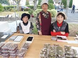 料理教室「すみれクラブ」の3人の女性たちが手作りの「丁稚ようかん」「桜餅」を販売している写真