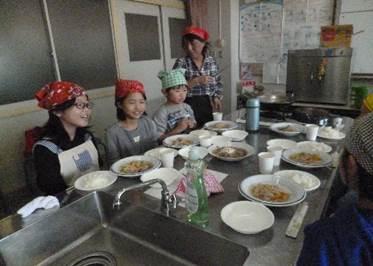 それぞれの調理が完了し、配膳して笑顔で座っている子供たちの写真