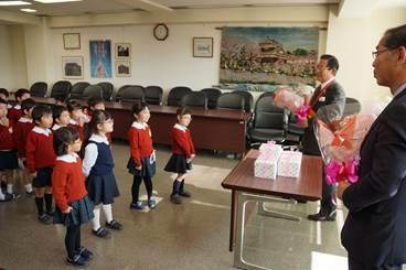 市役所にて大和郡山カトリック幼稚園の園児たちから感謝の花束をおくられた上田市長と谷垣教育長の写真