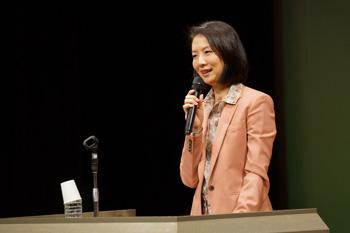 ステージ上でマイクを持ち講演する藤沢久美さんの写真