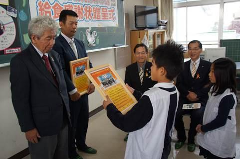 治道小学校の教室にて地元農家の代表に生徒から感謝状を贈呈する生徒の写真