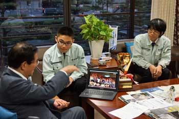 市長室にて市長に大会の様子をノートパソコンを使って説明をしているメンバーたちの写真