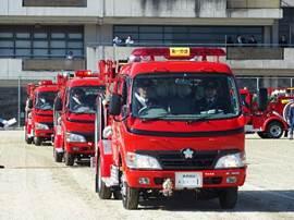 真っ赤な3台消防車が隊列を組んで走行している処の写真