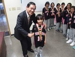 キャプテンの増田さんと市長を中心に、後ろで様子を伺うバスケットチームメンバーの写真