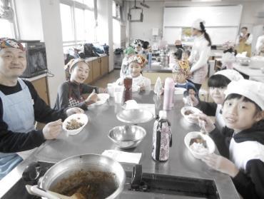 出来上がった本格派チキンカリーを実食する中学生たちの写真