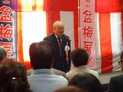 紅白の垂れ幕を背に開会宣言を行う「大和郡山盆梅展」実行委員会長の社員