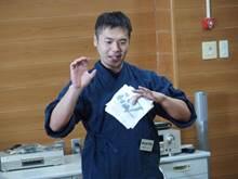 紺色の作業服に身を包んだ、講師の墨職人、松田さんの写真