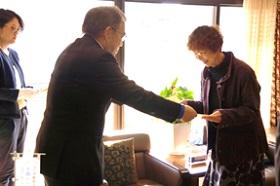 人権擁護委員として働いていた松本洋子さんが、男性から法務大臣からの感謝状を手渡された瞬間の写真
