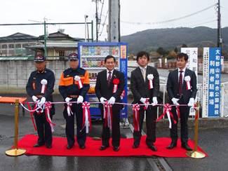 矢田分団庫前(矢田町)で行われた5人の消防、防犯関係者によるテープカットの瞬間の写真