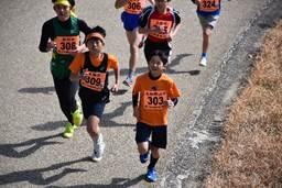 快調な走りでオレンジ色の子が、5人の他市町村の子供を先行している様子の写真
