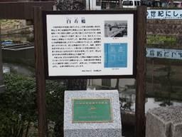 「百寿橋(ひゃくじゅばし)」を説明する看板と、下部に緑のプレートが付いた石碑の写真